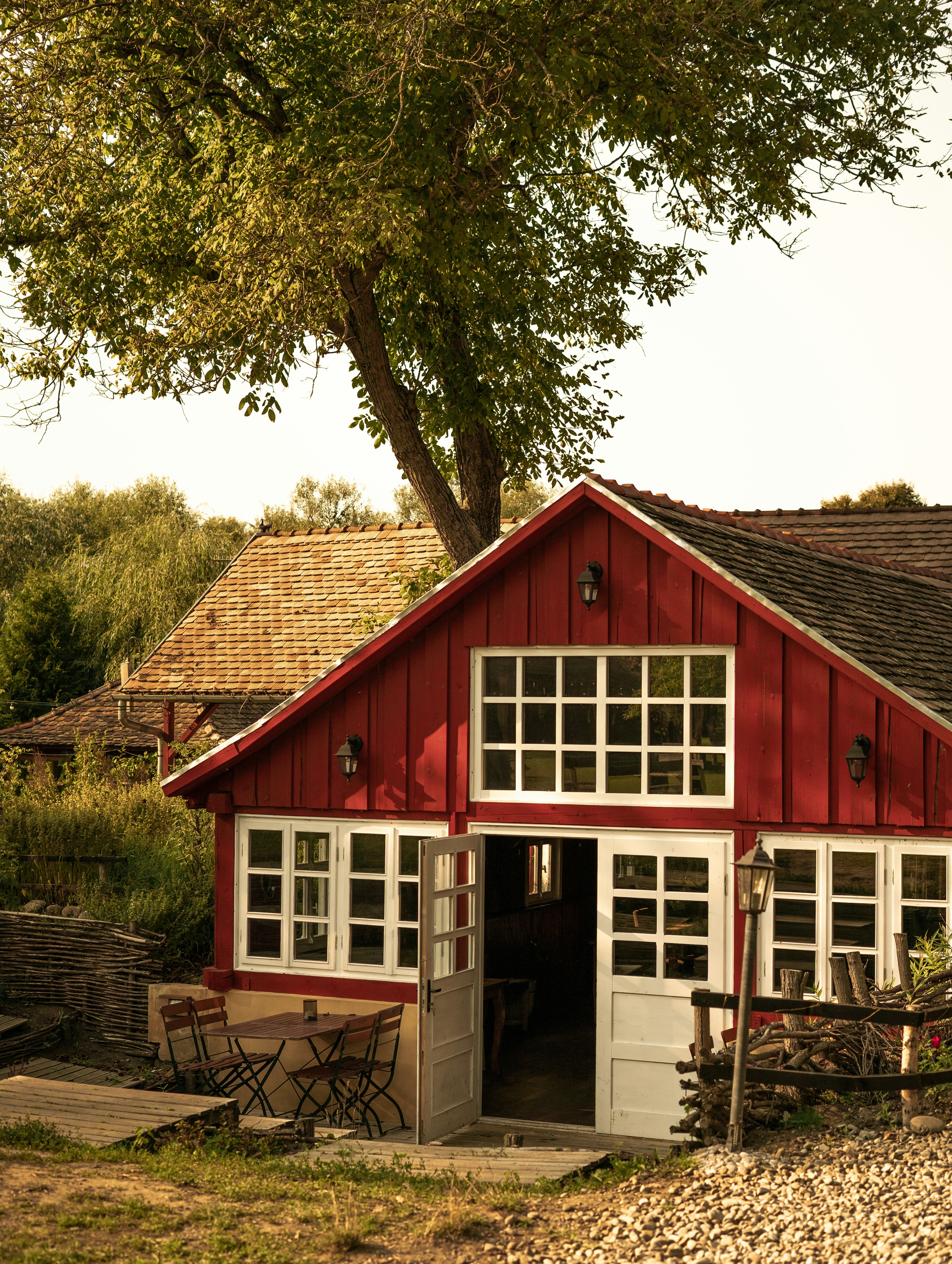 red wooden house near green trees during daytime